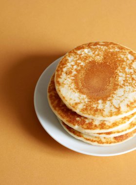 Turuncu arka planda izole edilmiş taze krep yığını. Lezzetli ev yapımı Amerikan kahvaltısı ya da öğle yemeği. Tam üstte.