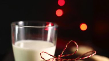 Noel kurabiyeleri. Kısa hamurlu bisküviler ve koyu bulanık ışıklı arka planda bir bardak süt. Noel ve tatil sezonu.