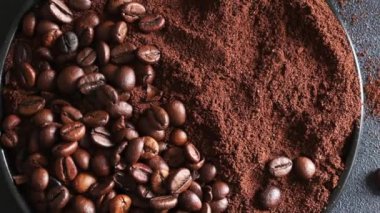 Kavrulmuş kahve çekirdekleri ve gri arka planda öğütülmüş kahve. Tam üstte.