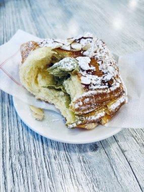 Kremayla dolu nefis puf böreği ve masaya serpiştirilmiş şeker. İtalyan kahvaltı konsepti.