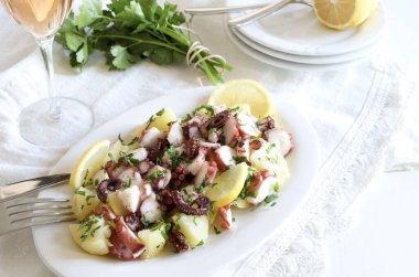 Maydanoz ve limonla süslenmiş taze ahtapot ve patates salatası. Aile toplantısı konsepti. Tam üstte.