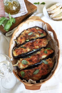 Mozarella peynirli ev yapımı patlıcan, doğranmış domates ve tepside taze fesleğen yaprağı. Vejetaryen yemeği. Tam üstte.