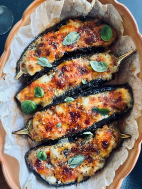Mozarella peynirli ev yapımı patlıcan, doğranmış domates ve tepside taze fesleğen yaprağı. Vejetaryen yemeği. Tam üstte.