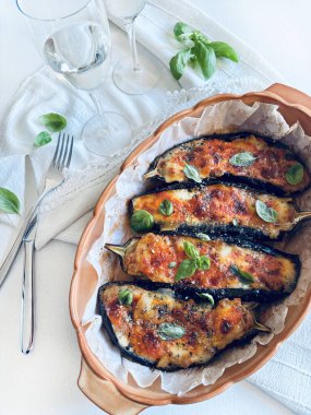 Mozarella peynirli ev yapımı patlıcan, doğranmış domates ve tepside taze fesleğen yaprağı. Vejetaryen yemeği. Tam üstte.