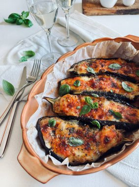 Mozarella peynirli ev yapımı patlıcan, doğranmış domates ve tepside taze fesleğen yaprağı. Vejetaryen yemeği. Tam üstte.