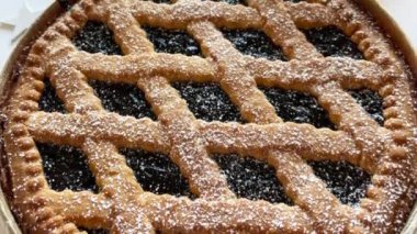 Gri bir tabakta reçelli ev yapımı Noel turtası, beyaz arka plan. Linzer turtası, Avusturya tatlısı. Noel süsleri. Tatil sezonu. Tam üstte.