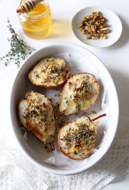 Gorgonzola peyniri, fındık, parmesan, bal ve taze kekik ile nefis pişmiş armutlar. Gurme aperatifi. Tam üstte.