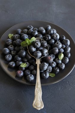 Yabanmersini meyveleri. Siyah arkaplanda taze organik yaban mersini grubu. Sağlıklı ve vejetaryen yemekleri. Tam üstte. Boşluğu kopyala.