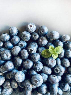 Yabanmersini meyveleri. Beyaz arka planda bir kasede taze organik yaban mersini grubu. Sağlıklı ve vejetaryen yemekleri. Tam üstte. Boşluğu kopyala.