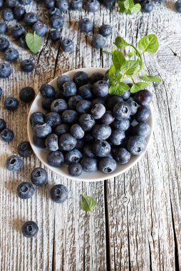 Yabanmersini meyveleri. Ahşap arka planda bir kasede taze organik yabanmersini grubu. Sağlıklı ve vejetaryen yemekleri. Tam üstte. Boşluğu kopyala.
