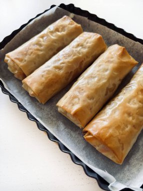 Beyaz ahşap bir masada fırında pişmiş taze fileto hamuru ruloları. Yemek pişirme, yemek pişirme, konsept. Tam üstte.