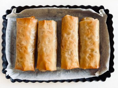 Beyaz ahşap bir masada fırında pişmiş taze fileto hamuru ruloları. Yemek pişirme, yemek pişirme, konsept. Tam üstte.