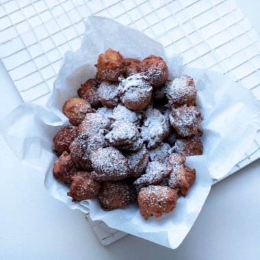 Geleneksel İtalyan karnaval tatlıları. Beyaz arka planda krema serpiştirilmiş sultanlarla ev yapımı karnaval börekleri.. 