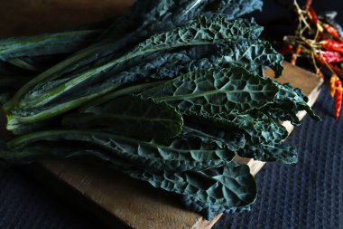 Tahta kesme tahtasında taze siyah lahana yaprakları. Kara lahana. İtalyan yemeği..