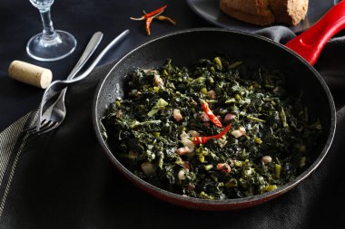 İtalyan yemeği kavramı. Sotelenmiş kara lahana ve pastırma. Kırsal meze. Tam üstte.