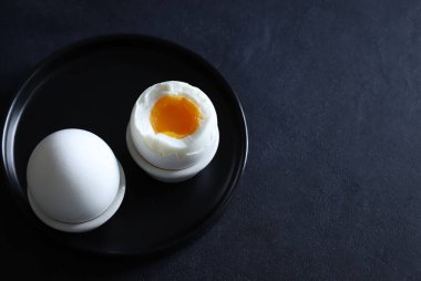 Siyah bir arka planda siyah bir tabakta rafadan yumurta. Sağlıklı yiyecekler. Tam üstte.