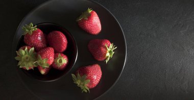Karanlık bir arka planda izole edilmiş taze çilekler. Sağlıklı ve vejetaryen yemekleri. Tam üstte, boşluğu kopyala.