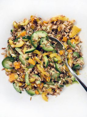 Beyaz arka planda pişmiş sebzelerle (kabak, havuç, biber) pişirilmiş mısır gevreği karışımı. Vejetaryen ve sağlıklı yiyecekler. Tam üstte.