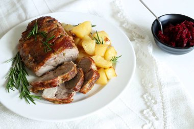 Dilimlenmiş hindi yahnisi manzarası. Beyaz bir tabakta kızarmış hindi, patates ve beyaz ahşap bir masada biberiye..