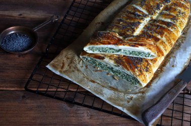 Kırsal ahşap arka planda ricotta peynirli ve ıspanaklı ev yapımı lezzetli turta. Vejetaryen yemeği..