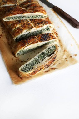 Beyaz ahşap arka planda ricotta peynirli ve ıspanaklı ev yapımı lezzetli turta. Vejetaryen yemeği..