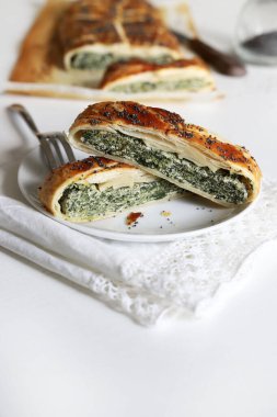 Beyaz ahşap arka planda ricotta peynirli ve ıspanaklı ev yapımı lezzetli turta. Vejetaryen yemeği..