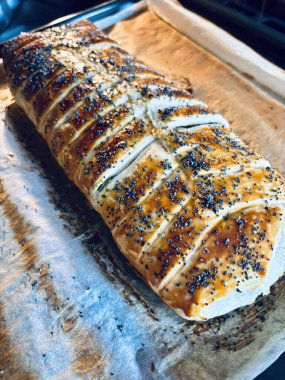 Pişirme kağıdına haşhaş tohumu serpiştirilmiş ev yapımı lezzetli turta. Tam üstte.