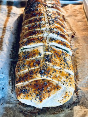 Pişirme kağıdına haşhaş tohumu serpiştirilmiş ev yapımı lezzetli turta. Tam üstte.