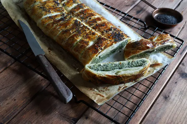 Kırsal ahşap arka planda ricotta peynirli ve ıspanaklı ev yapımı lezzetli turta. Vejetaryen yemeği..