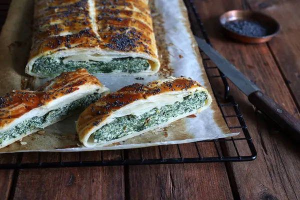 Kırsal ahşap arka planda ricotta peynirli ve ıspanaklı ev yapımı lezzetli turta. Vejetaryen yemeği..