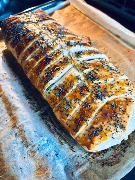 Pişirme kağıdına haşhaş tohumu serpiştirilmiş ev yapımı lezzetli turta. Tam üstte.