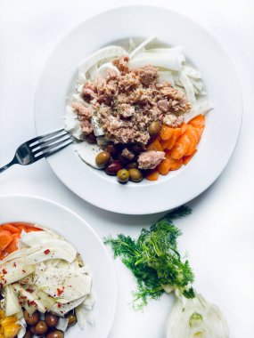 Ton balığı ve taze sebzeli rezene salatası, beyaz arka planda izole edilmiş havuç zeytinleri. Sağlıklı yiyecekler. Tam üstte.