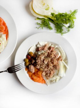 Ton balığı ve taze sebzeli rezene salatası, beyaz arka planda izole edilmiş havuç zeytinleri. Sağlıklı yiyecekler. Tam üstte.