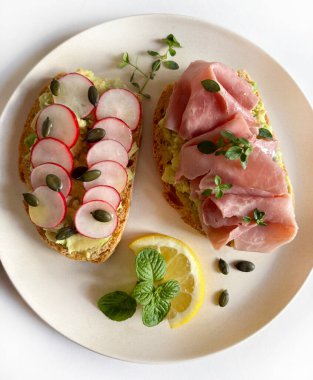 Prosciutto, turp, şifalı ot ve limonlu leziz avokado tostu. Sağlıklı yiyecekler. Tam üstte.