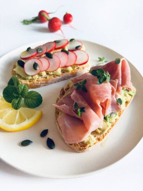 Prosciutto, turp, şifalı ot ve limonlu leziz avokado tostu. Sağlıklı yiyecekler. Tam üstte.