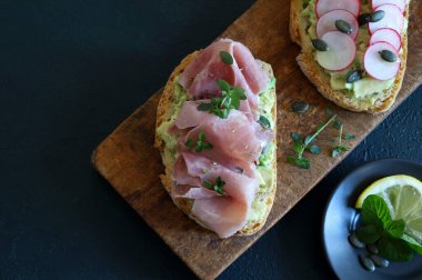 Prosciutto, turp, şifalı ot ve limonlu lezzetli avokado tostu. Sağlıklı yiyecekler. Tam üstte.