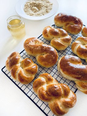 Geleneksel Romanya pastası. Ev yapımı Mucenici. Şekil 8 'de yapılan tatlılar çelenk şeklinde. Beyaz bir masaya bal ve doğranmış fındık sürülmüş. Tam üstte.