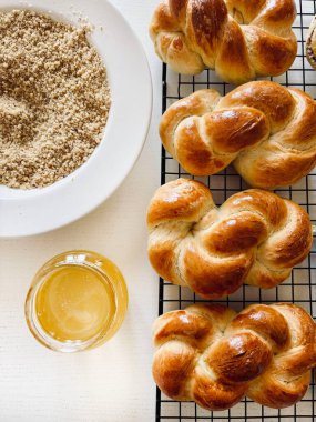 Geleneksel Romanya pastası. Ev yapımı Mucenici. Şekil 8 'de yapılan tatlılar çelenk şeklinde. Beyaz bir masaya bal ve doğranmış fındık sürülmüş. Tam üstte.