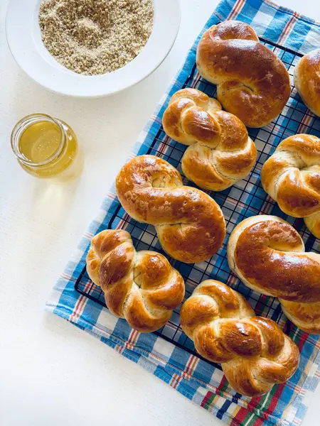 Geleneksel Romanya pastası. Ev yapımı Mucenici. Şekil 8 'de yapılan tatlılar çelenk şeklinde. Beyaz bir masaya bal ve doğranmış fındık sürülmüş. Tam üstte.