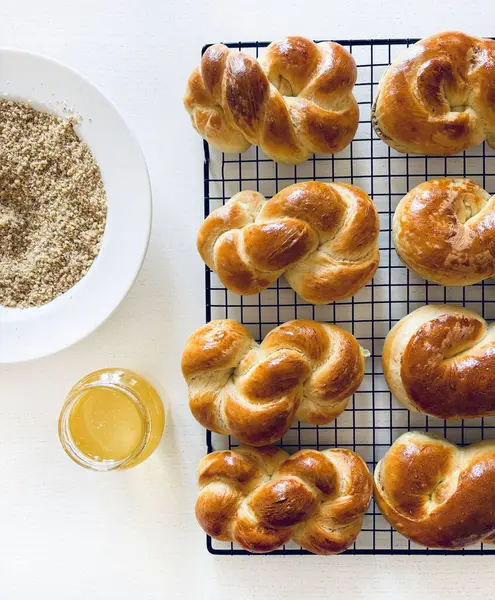 Geleneksel Romanya pastası. Ev yapımı Mucenici. Şekil 8 'de yapılan tatlılar çelenk şeklinde. Beyaz bir masaya bal ve doğranmış fındık sürülmüş. Tam üstte.