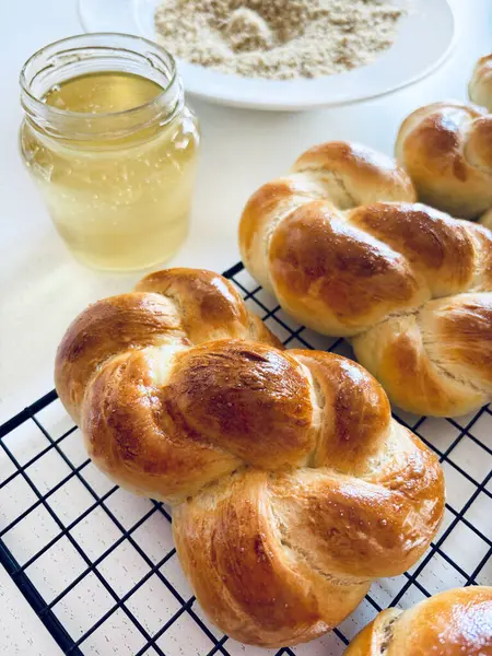 Geleneksel Romanya pastası. Ev yapımı Mucenici. Şekil 8 'de yapılan tatlılar çelenk şeklinde. Beyaz bir masaya bal ve doğranmış fındık sürülmüş. Tam üstte.