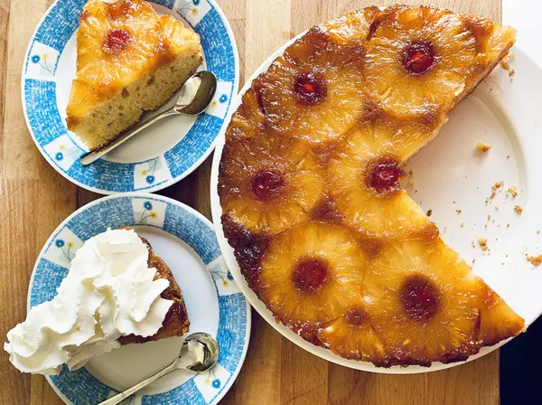 Ev yapımı ananaslı kek ve ahşap arka planda şekerli kirazlar. Tam üstte.