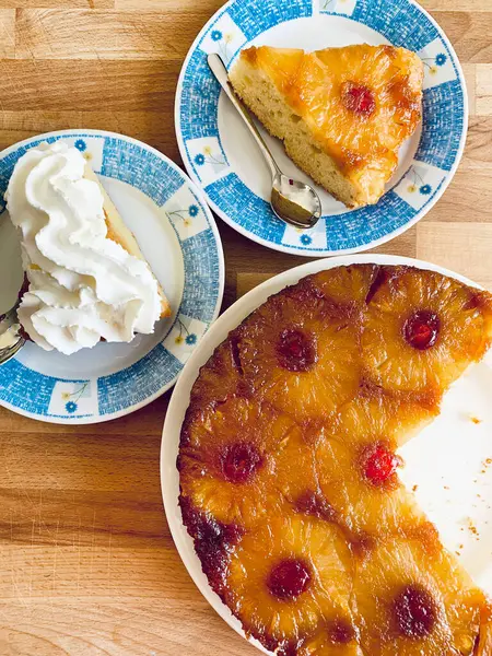 Ev yapımı ananaslı kek ve ahşap arka planda şekerli kirazlar. Tam üstte.