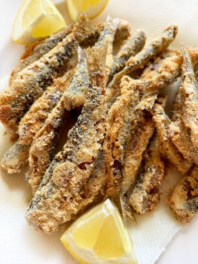 Beyaz tabakta kızarmış sardalya ve limon. Sağlıklı Akdeniz mezeleri. Deniz ürünleri konsepti.