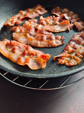 Kızartma tavasında kızarmış pastırma dilimleri. Lezzetli kızarmış pastırma. Sağlıksız yiyecekler. Tam üstte.