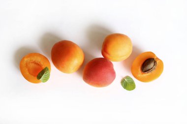 Beyaz arka planda izole edilmiş taze nane yapraklarıyla dekore edilmiş bir grup taze kayısı. Yaz meyvesi. Sağlıklı yiyecekler. Tam üstte.