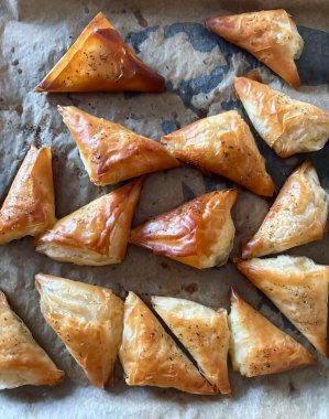 Lezzetli fırın doldurulmuş puf böreği üçgenleri, sadece fırından, yemeye hazır. İştah açıcı yemek. Tam üstte.