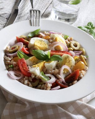 Haşlanmış yumurtalı ev yapımı salata, taze sebze ve ahşap arka planda fesleğen. Hecelenmiş salata. Sağlıklı yiyecekler. Tam üstte.