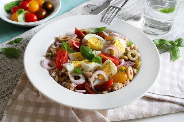 Haşlanmış yumurtalı ev yapımı salata, taze sebze ve ahşap arka planda fesleğen. Hecelenmiş salata. Sağlıklı yiyecekler. Tam üstte.