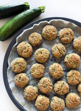 Beyaz ahşap bir masada ev yapımı kabak topları. Sağlıklı ve vejetaryen yemekleri. Uzayı kopyala Tam üstte.